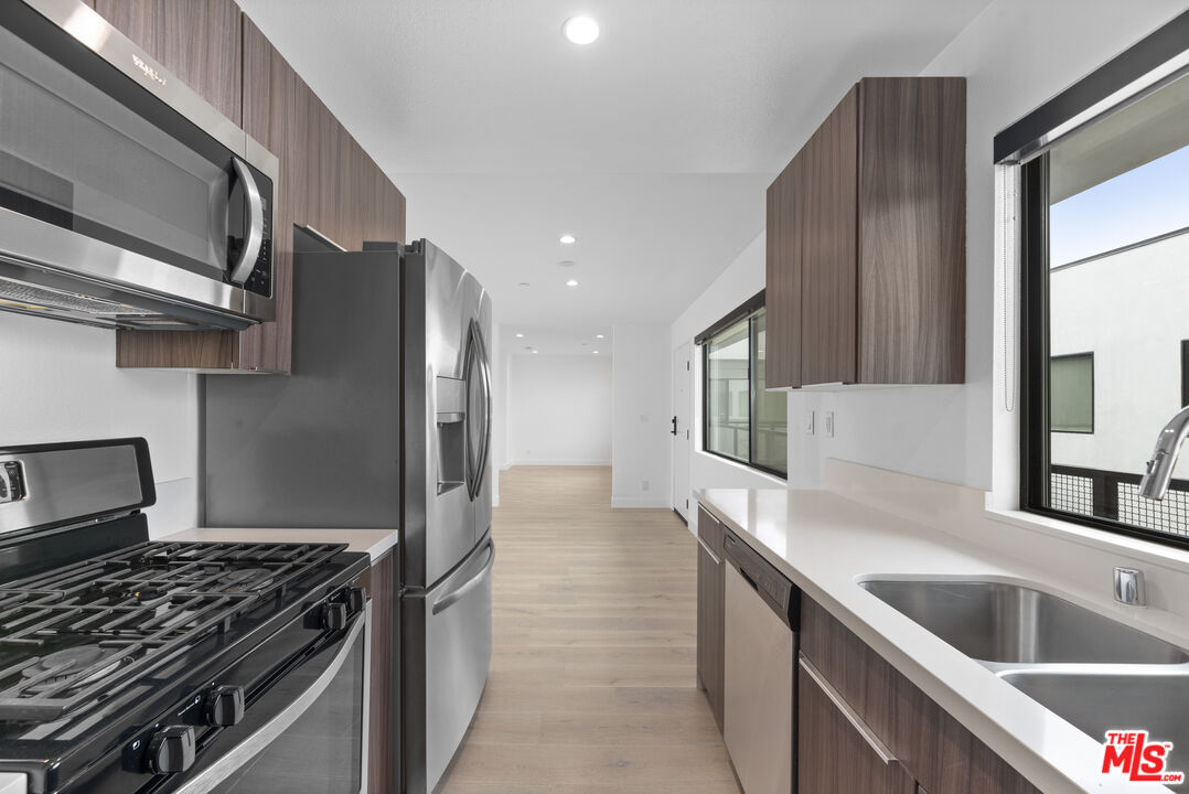 725 North Alfred Street, Unit 202 Los Angeles, CA 90069 - Photo 8 of 28 a kitchen with stainless steel appliances granite countertop a sink and a stove