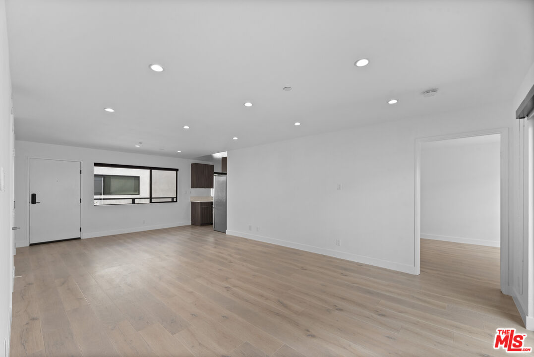 725 North Alfred Street, Unit 202 Los Angeles, CA 90069 - Photo 9 of 28 an empty room with wooden floor and windows