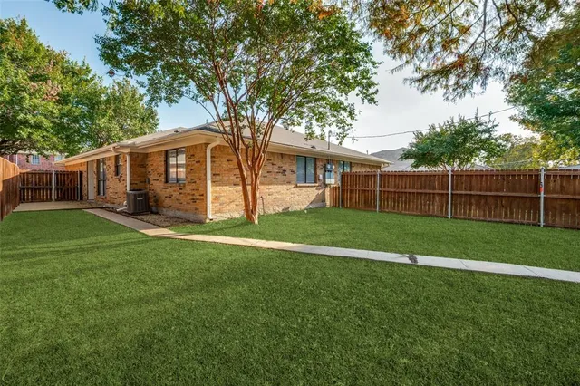 a view of a house with a big yard and large trees