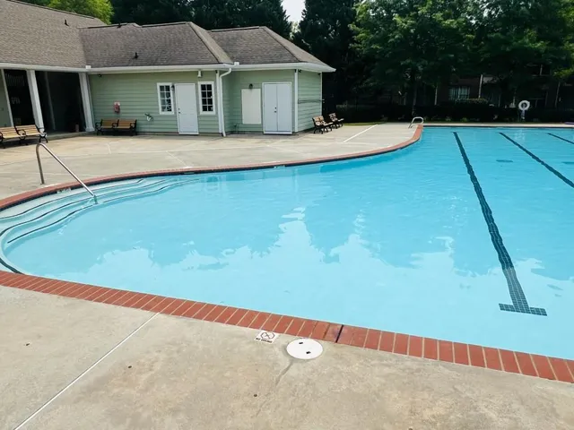 a view of house with yard and swimming pool