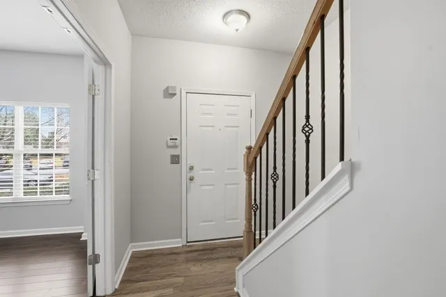 a view of a hallway with wooden floor and staircase