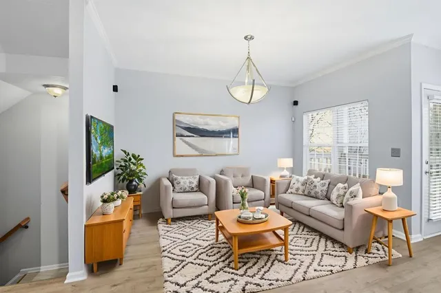 a living room with furniture and a chandelier