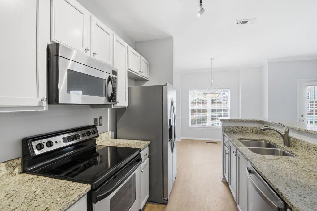 1732 Pryor Road Southwest, Unit 803 Atlanta, GA 30315 - Photo 8 of 26 a kitchen with granite countertop a refrigerator stove and microwave