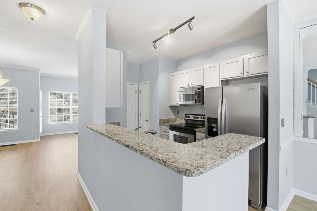 1732 Pryor Road Southwest, Unit 803 Atlanta, GA 30315 - Photo 9 of 26 a kitchen with granite countertop a refrigerator and microwave