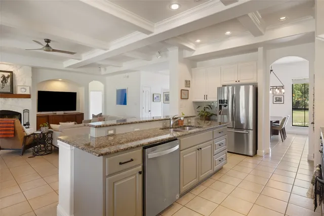 a kitchen with stainless steel appliances granite countertop a sink and a refrigerator