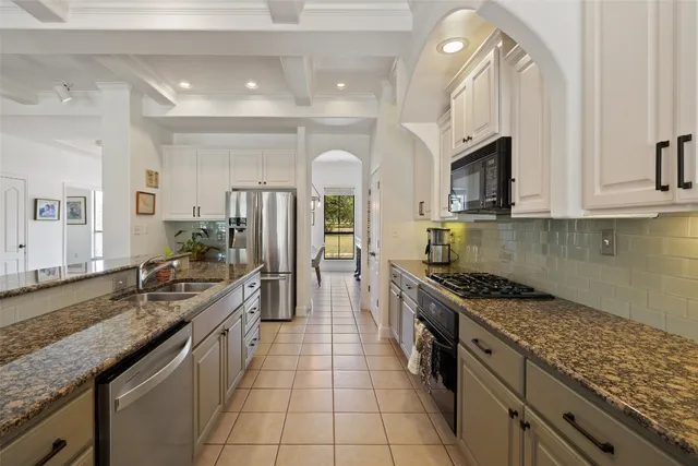 a large kitchen with stainless steel appliances granite countertop a sink stove and refrigerator