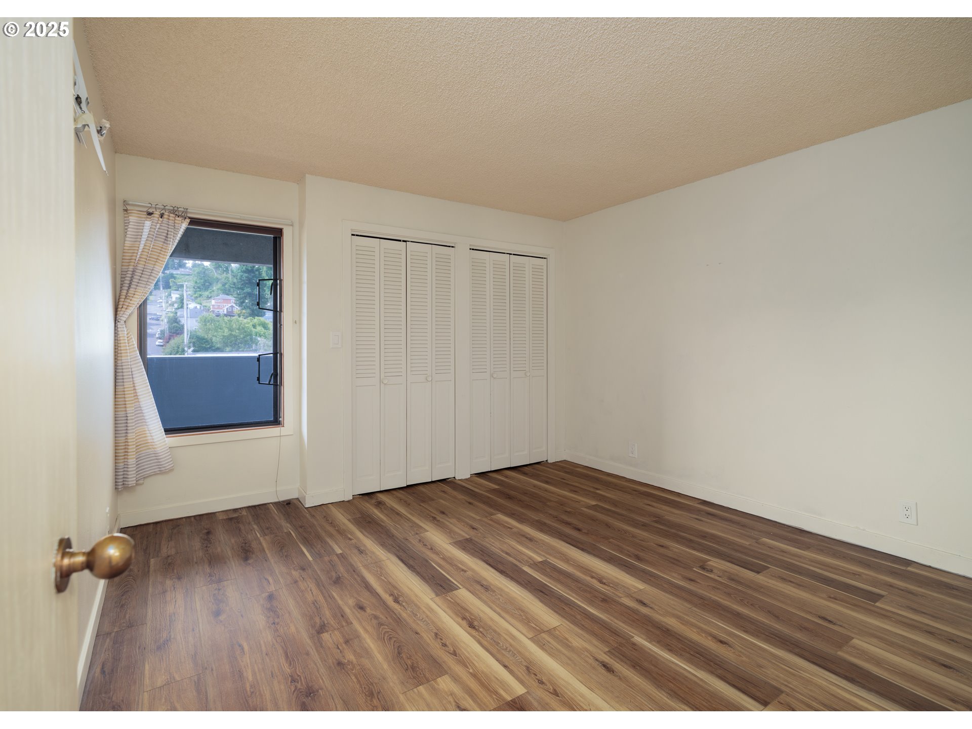 1 3rd Street, Unit 209 Astoria, OR 97103 - Photo 22 of 37 a view of an empty room with wooden floor and a window