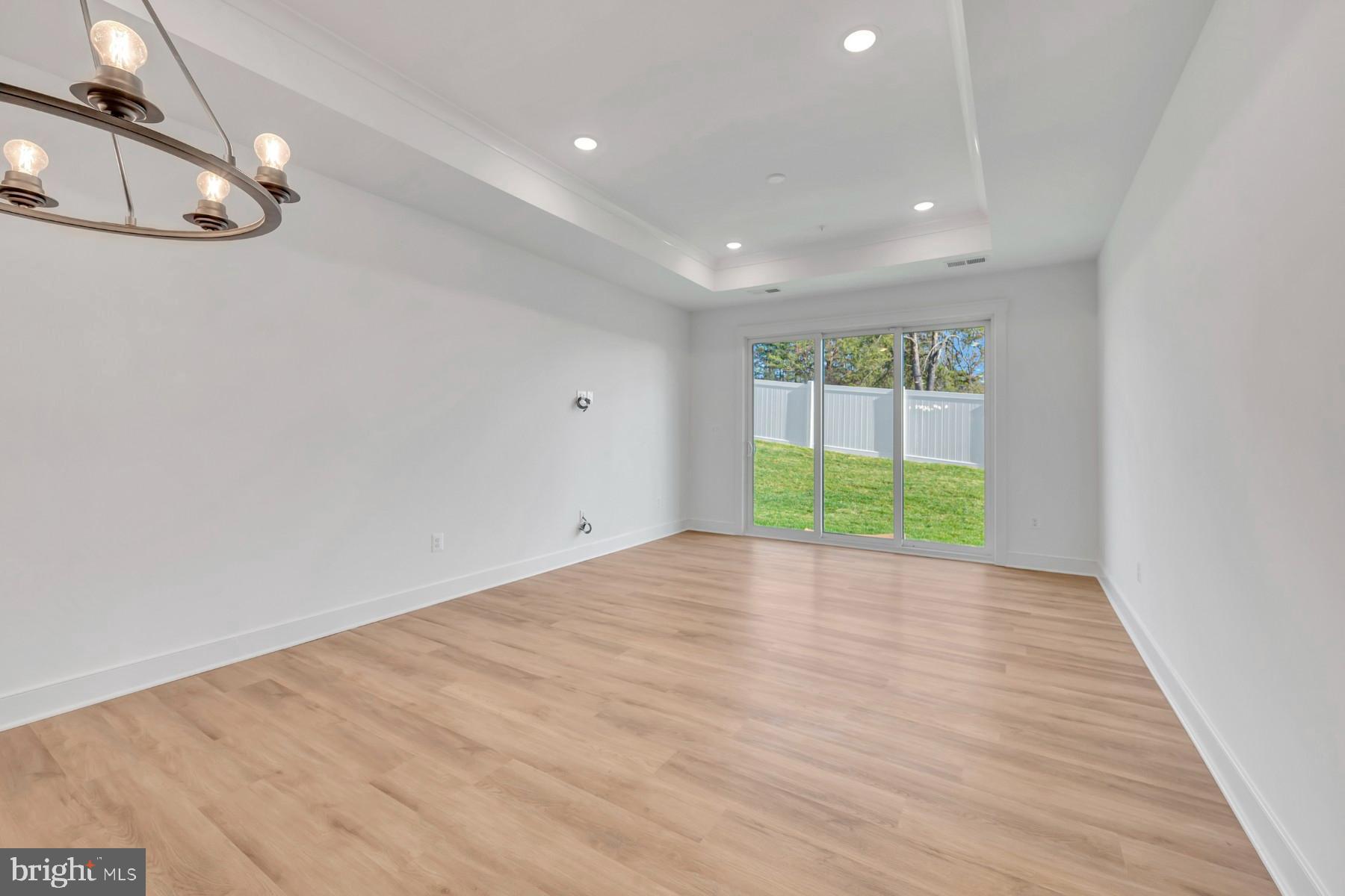 4803 Grandiflora Circle Perry Hall, MD 21128 - Photo 9 of 30 a view of an empty room with wooden floor and fan