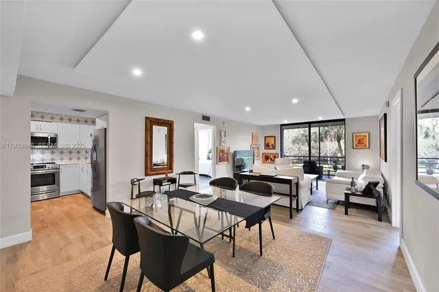 a living room with lots of furniture wooden floor and a large window