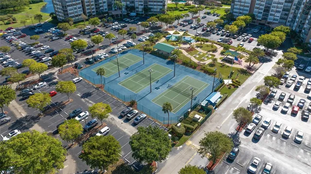 an aerial view of residential houses with outdoor space and trees