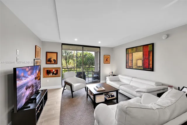 a living room with furniture a flat screen tv and a floor to ceiling window