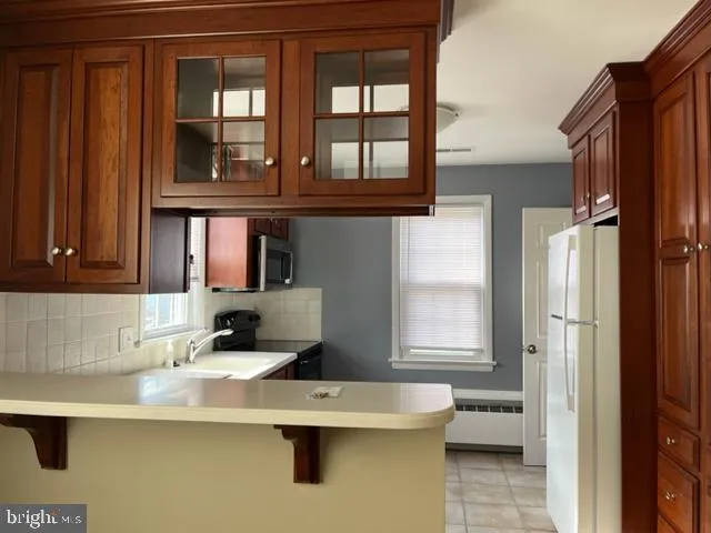 a kitchen with a sink a refrigerator and cabinets