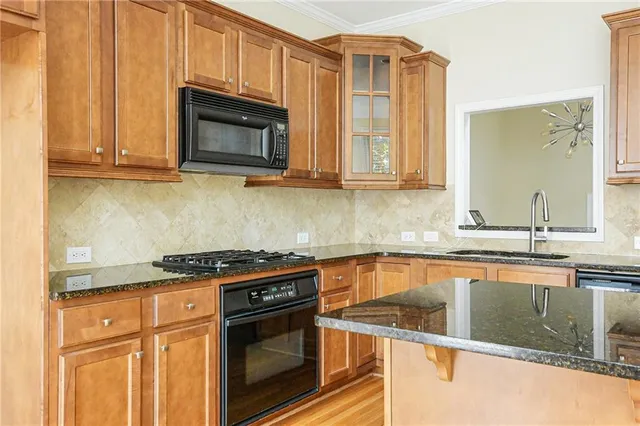 a kitchen with granite countertop a stove top oven microwave and cabinets