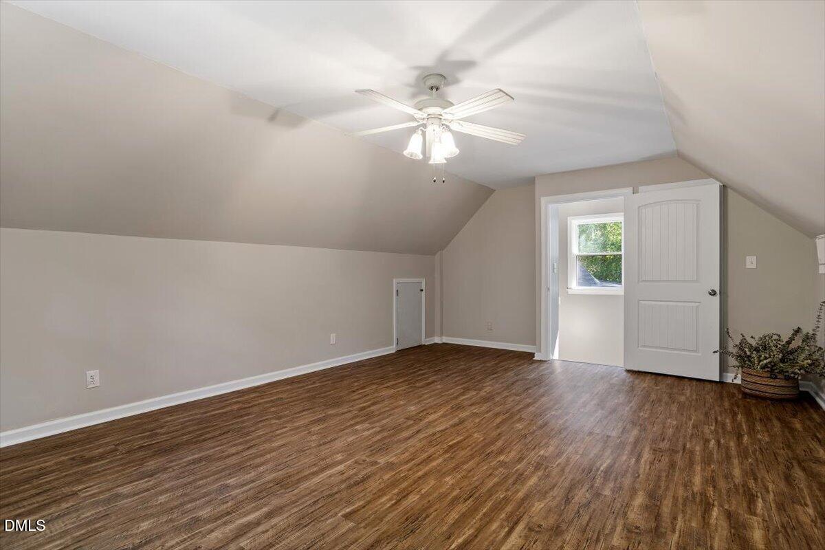 7505 Penny Road Raleigh, NC 27606 - Photo 26 of 35 an empty room with wooden floor chandelier fan and windows