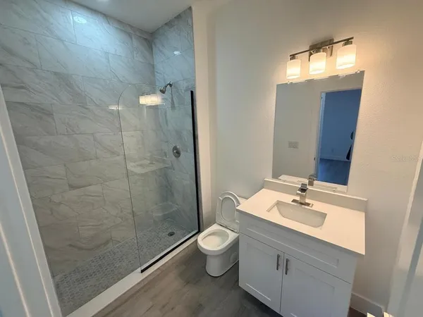 a bathroom with a double vanity sink toilet and shower