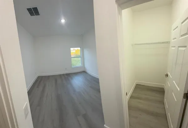 a view of an empty room with wooden floor