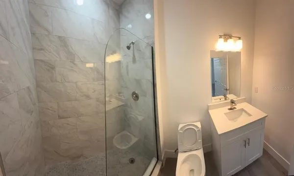 a bathroom with a sink mirror and shower
