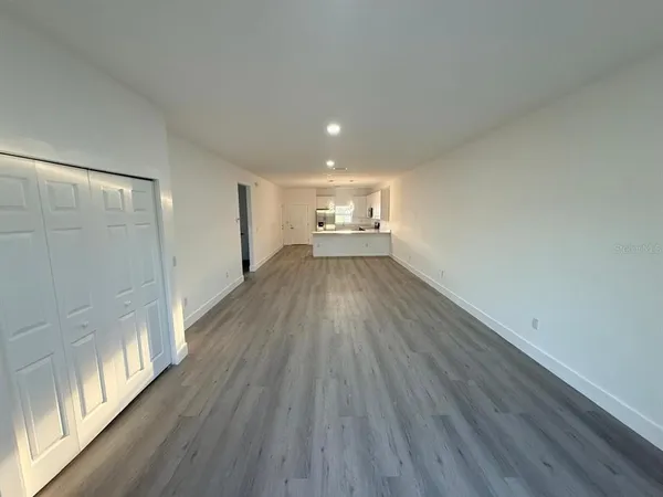 a view of empty room with wooden floor