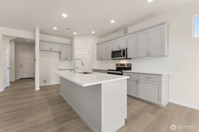 a kitchen with white cabinets and stainless steel appliances