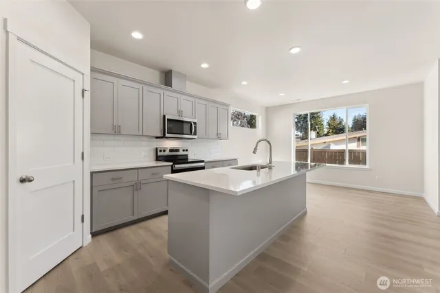 a kitchen with white cabinets and appliances