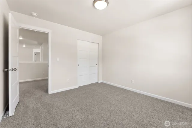 an empty room with closet and mirror