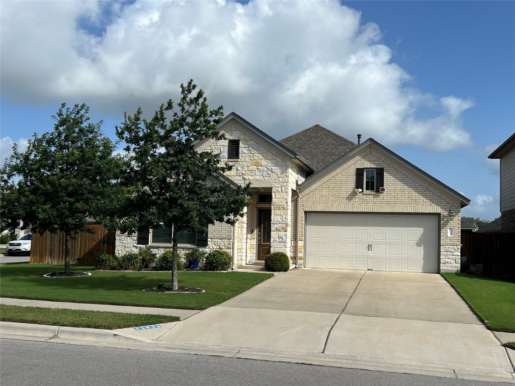 a front view of a house with a yard and a garage