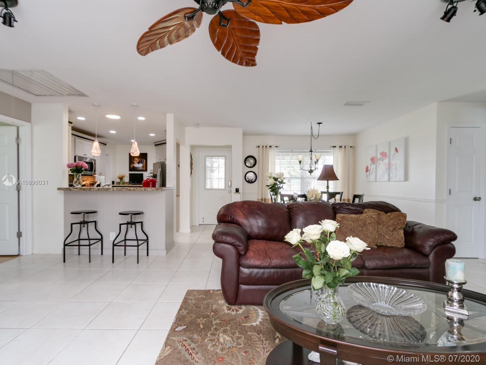 9518 Burlington Place Boca Raton, FL 33434 - Photo 16 of 35 a living room with furniture kitchen chandelier and a view of kitchen