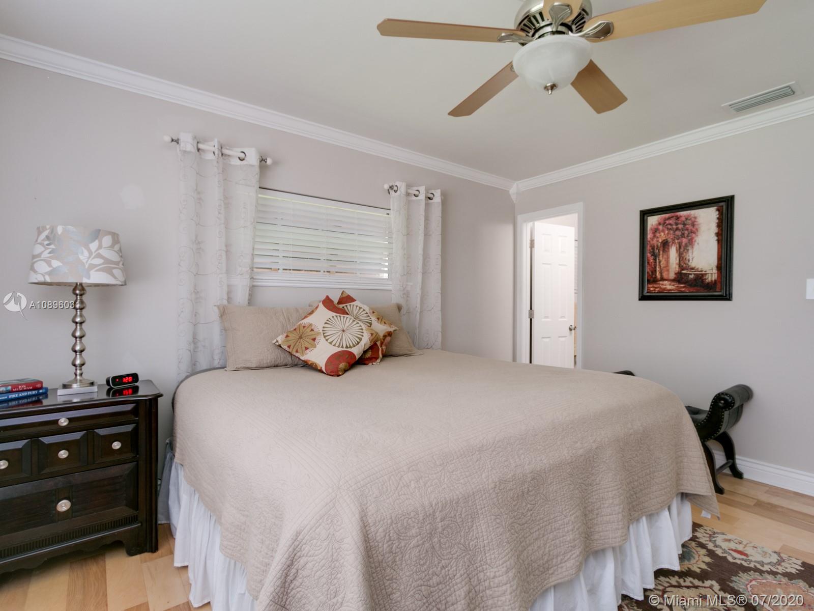 9518 Burlington Place Boca Raton, FL 33434 - Photo 22 of 35 a bedroom with a bed and a chandelier