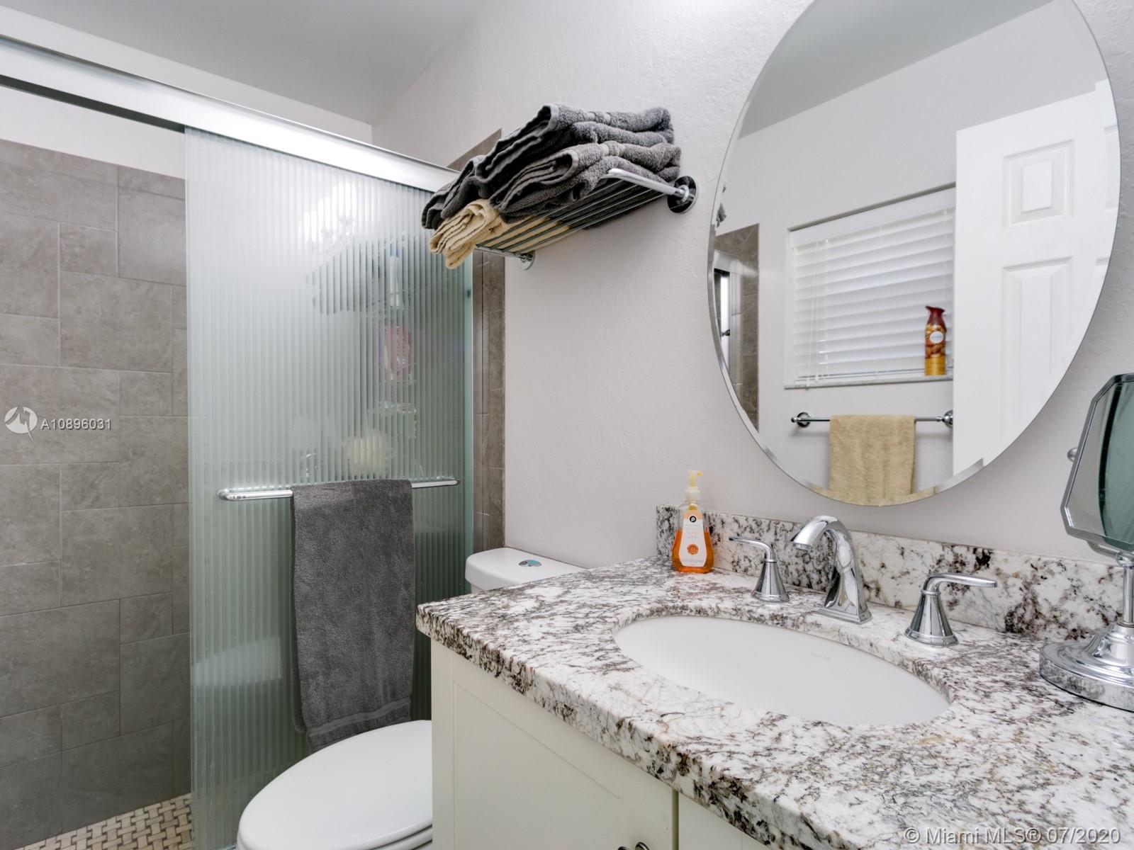 9518 Burlington Place Boca Raton, FL 33434 - Photo 23 of 35 a bathroom with a granite countertop sink toilet and shower