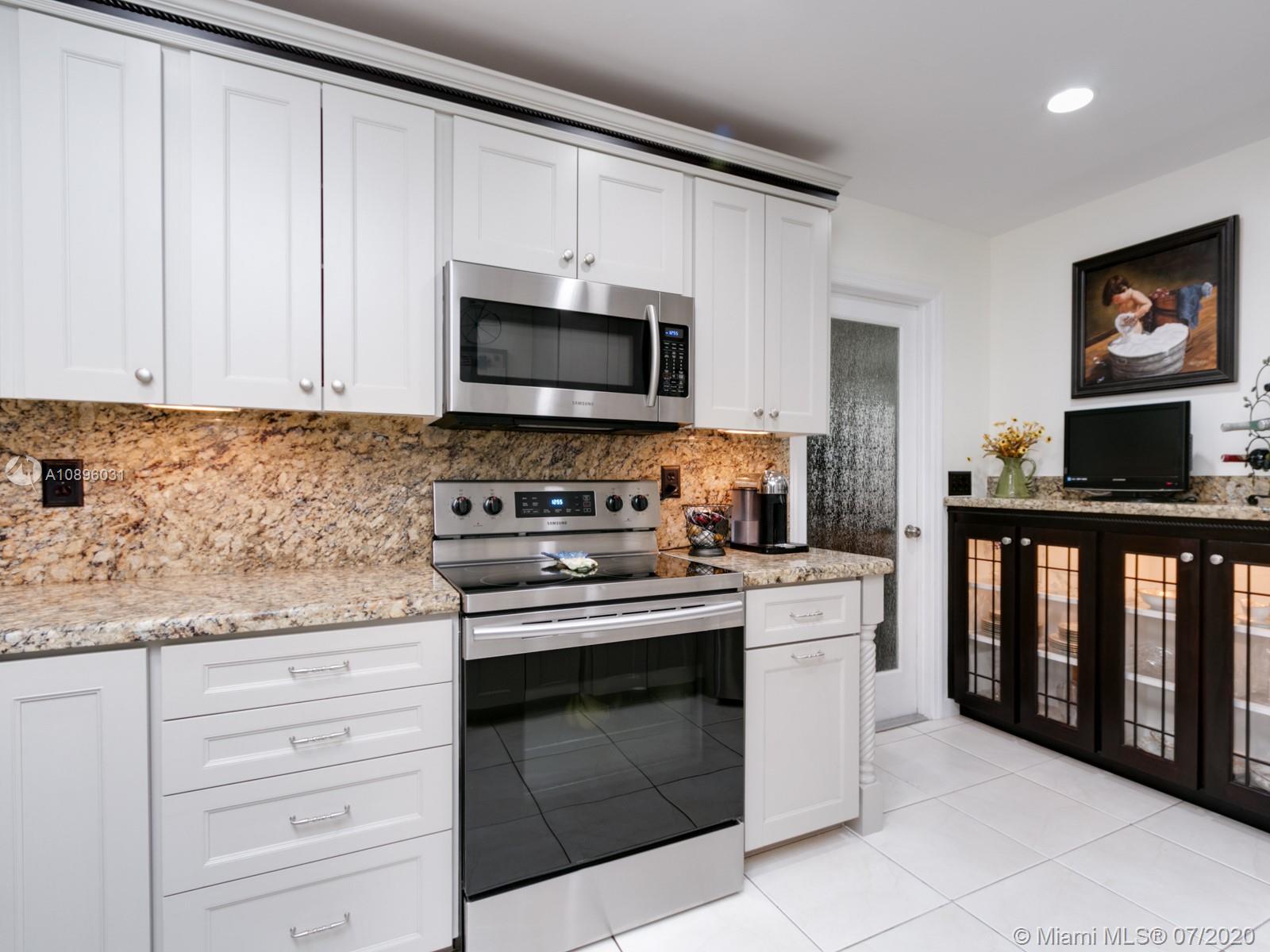 9518 Burlington Place Boca Raton, FL 33434 - Photo 7 of 35 a kitchen with stainless steel appliances granite countertop a stove and a microwave