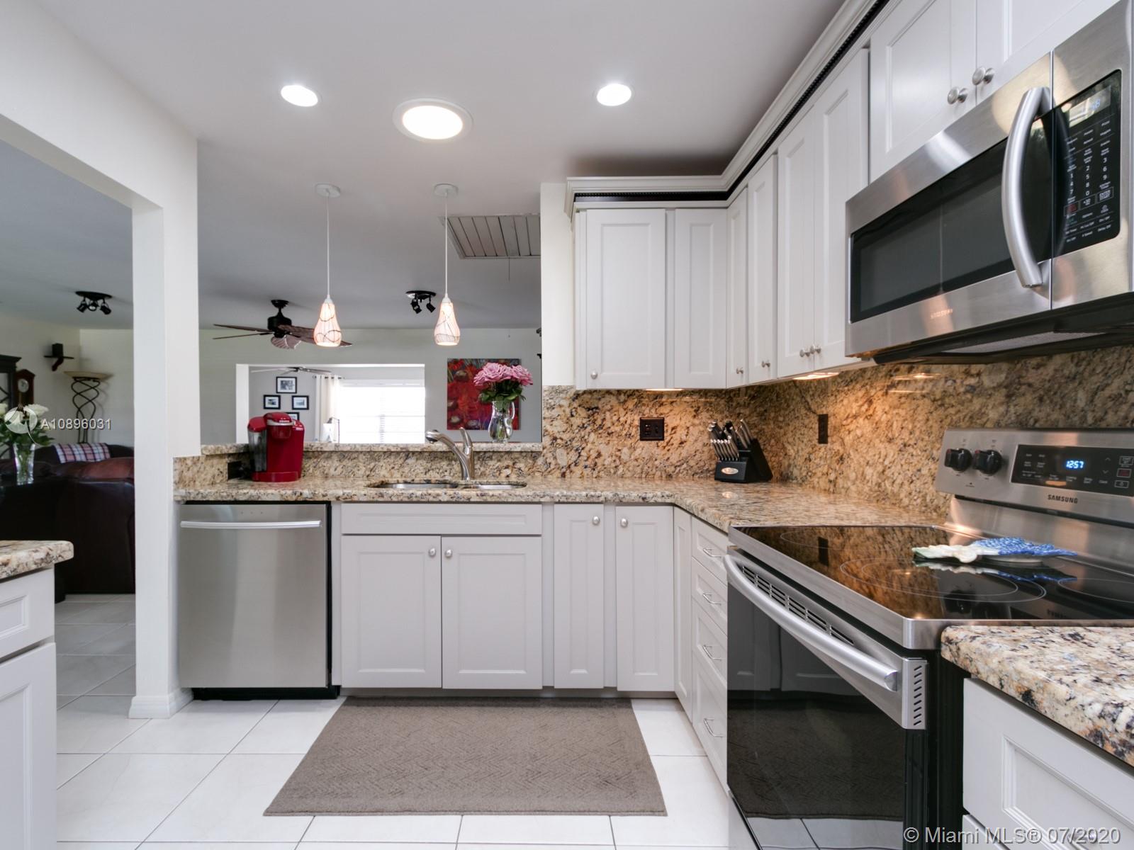 9518 Burlington Place Boca Raton, FL 33434 - Photo 10 of 35 a kitchen with stainless steel appliances granite countertop a sink and a stove