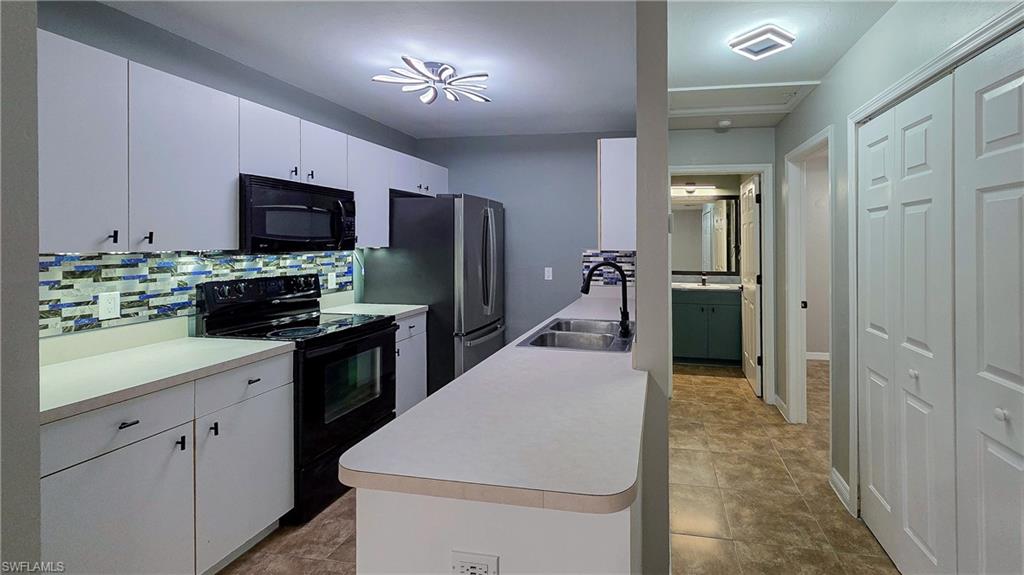 7319 Albany Road Fort Myers, FL 33967 - Photo 12 of 27 a kitchen that has a lot of cabinets a sink and appliances