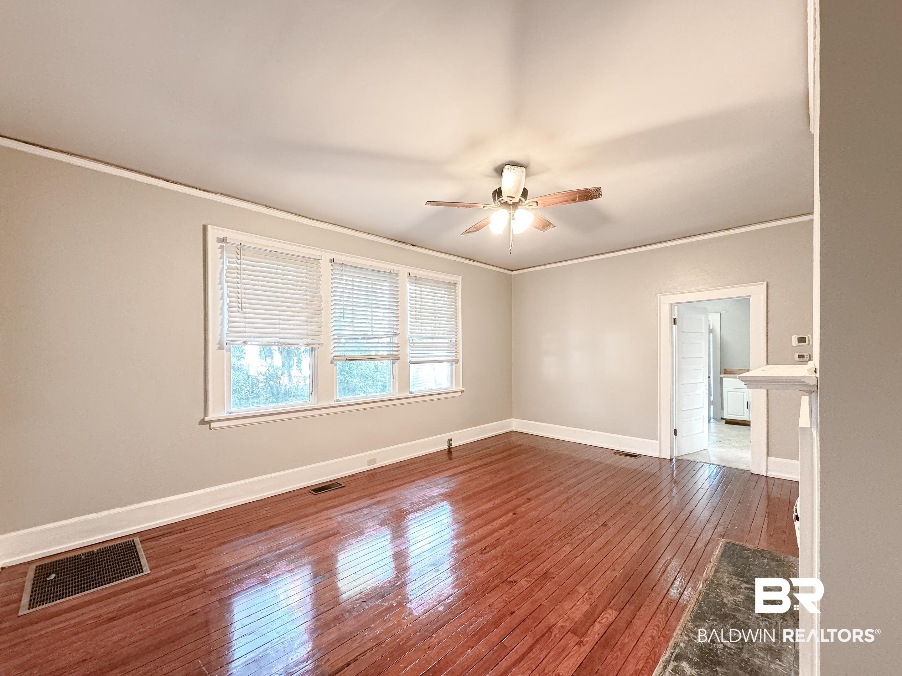 206 1st Street Mobile, AL 36611 - Photo 8 of 26 Unfurnished room with crown molding, hardwood / wood-style flooring, and a ceiling fan