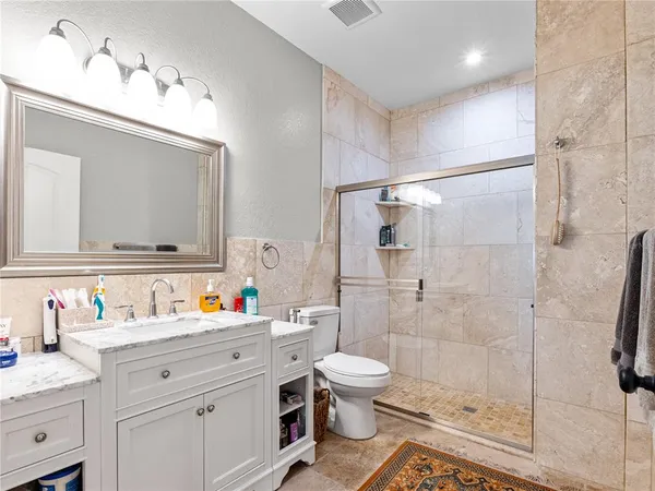 a bathroom with a sink toilet vanity and shower