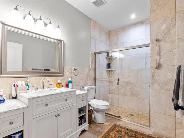 a bathroom with a sink toilet vanity and shower