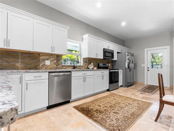 a kitchen with granite countertop a sink stainless steel appliances and cabinets