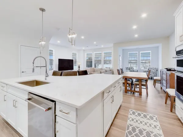 a large kitchen with sink a counter space and stainless steel appliances