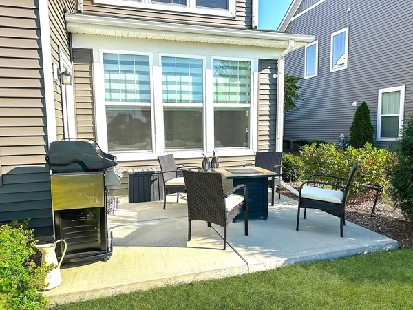 a view of a patio with table and chairs potted plants and wooden floor