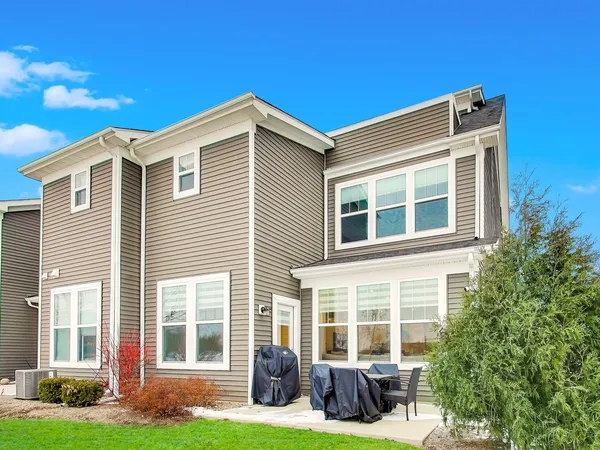 a front view of a house with a yard and outdoor seating