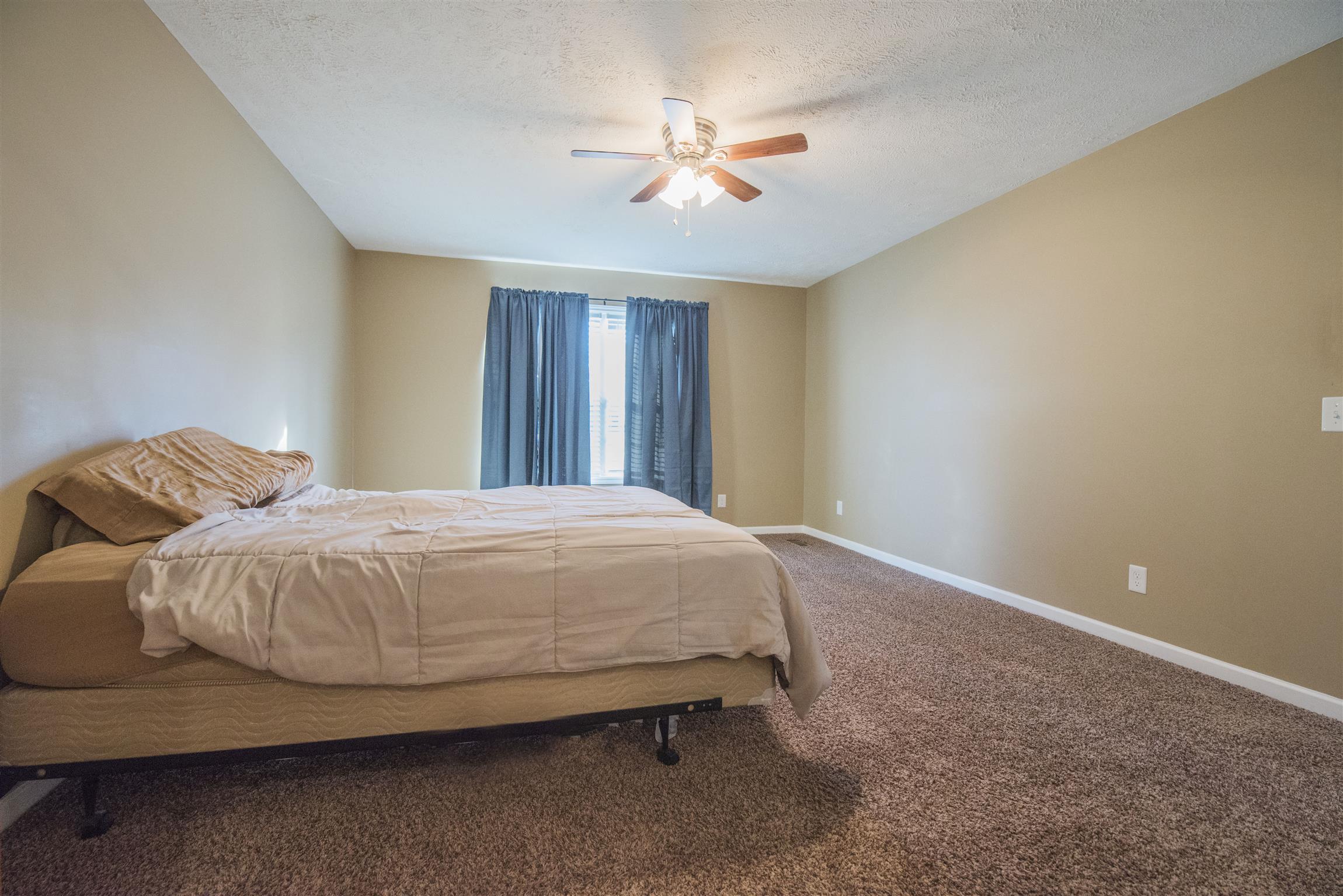 148 New Hope Road Manchester, TN 37355 - Photo 18 of 30 a spacious bedroom with a bed and a ceiling fan