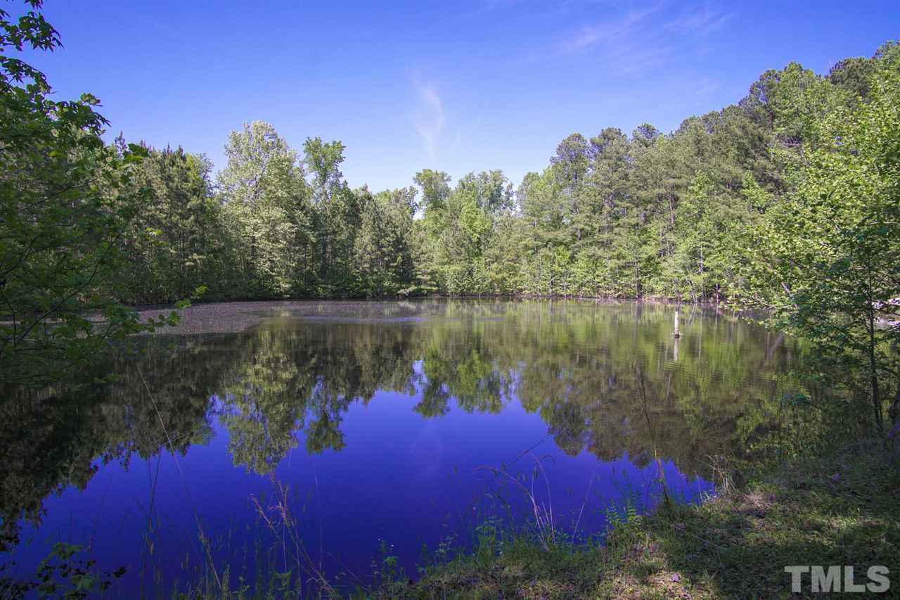 371 Lassiter Road Pittsboro, NC 27312 - Photo 19 of 19 a body of water with a building in the background
