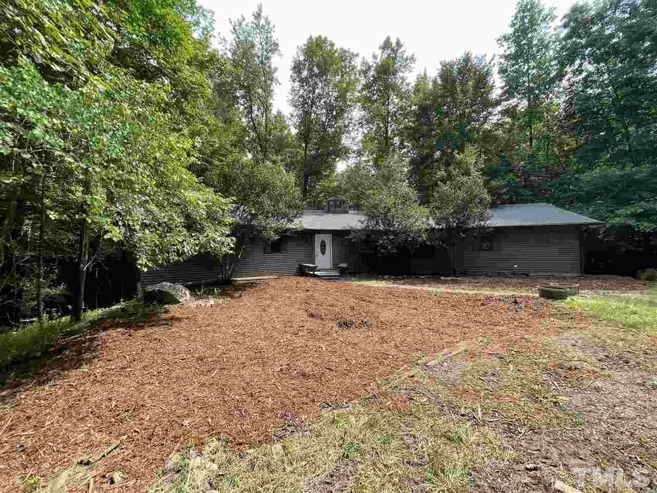 371 Lassiter Road Pittsboro, NC 27312 - Photo 3 of 19 a front view of a house with a yard and a garage