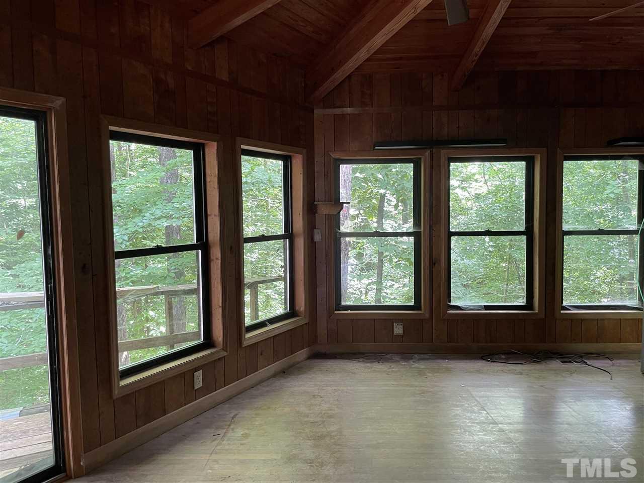 371 Lassiter Road Pittsboro, NC 27312 - Photo 10 of 19 a view of an empty room with wooden floor and a floor to ceiling window