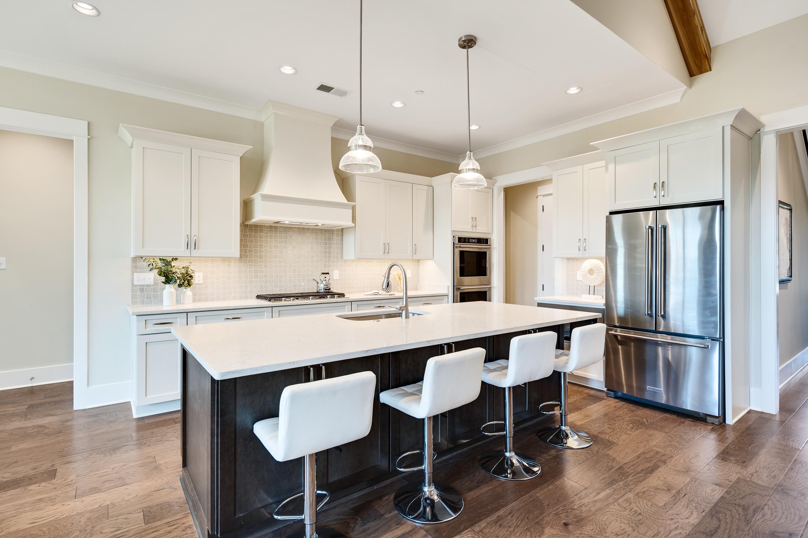 10136 Cliveden Circle North Collierville, TN 38017 - Photo 12 of 39 Kitchen with stainless steel appliances, custom range hood, dark wood-type flooring, white cabinets, and crown molding