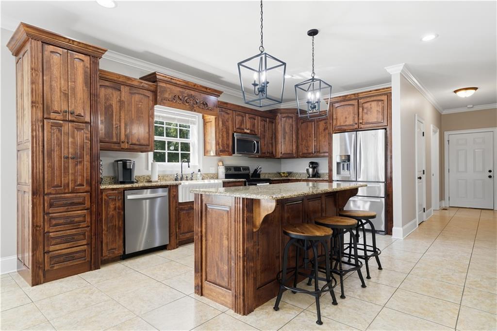 310 Gaines Road Southeast Dalton, GA 30721 - Photo 11 of 53 a kitchen with stainless steel appliances granite countertop a stove top oven a refrigerator a sink dishwasher a dining table and chairs with wooden floor
