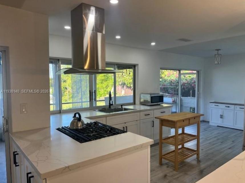 7281 Sunset Strip Sunrise, FL 33313 - Photo 7 of 25 a kitchen with a stove a sink a table and chairs