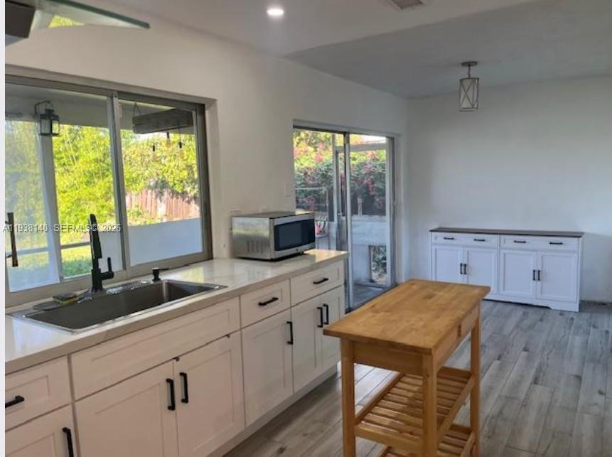 7281 Sunset Strip Sunrise, FL 33313 - Photo 10 of 25 a kitchen with a table chairs sink and cabinets