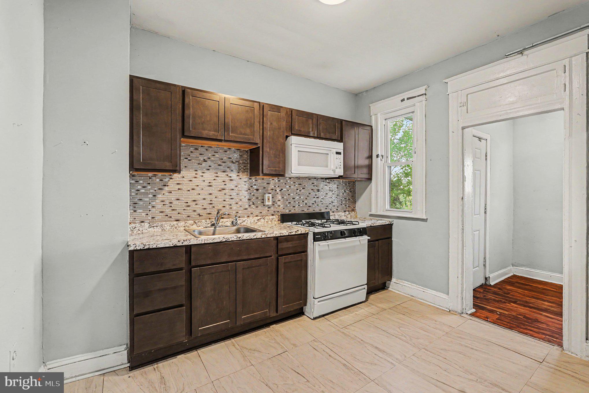 409 Edgewood Street Baltimore, MD 21229 - Photo 12 of 30 a kitchen with stainless steel appliances granite countertop a sink and a stove