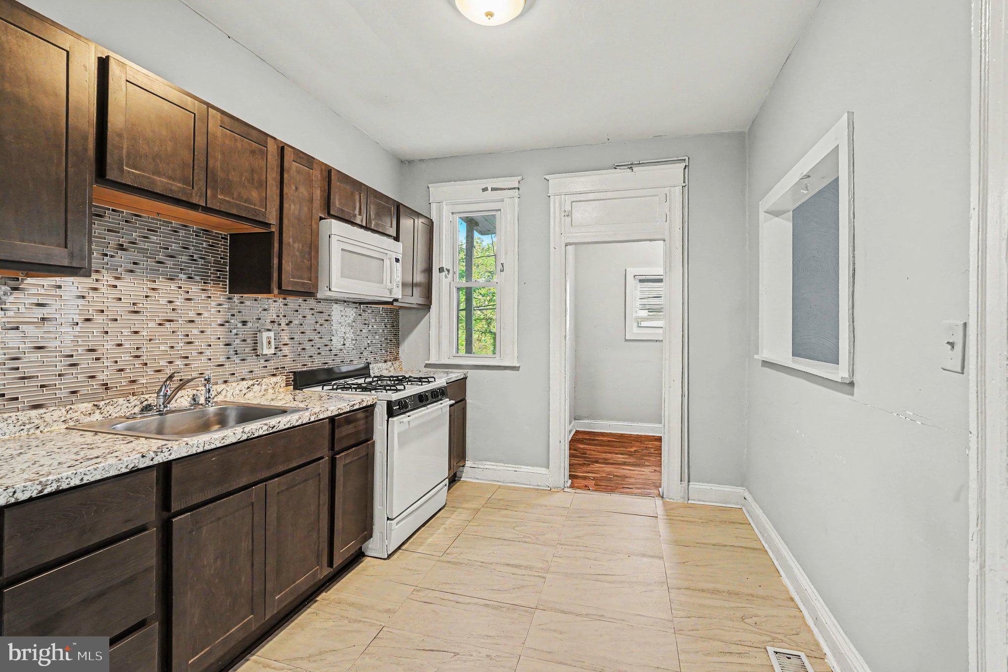 409 Edgewood Street Baltimore, MD 21229 - Photo 14 of 30 a kitchen with stainless steel appliances granite countertop a sink stove and cabinets