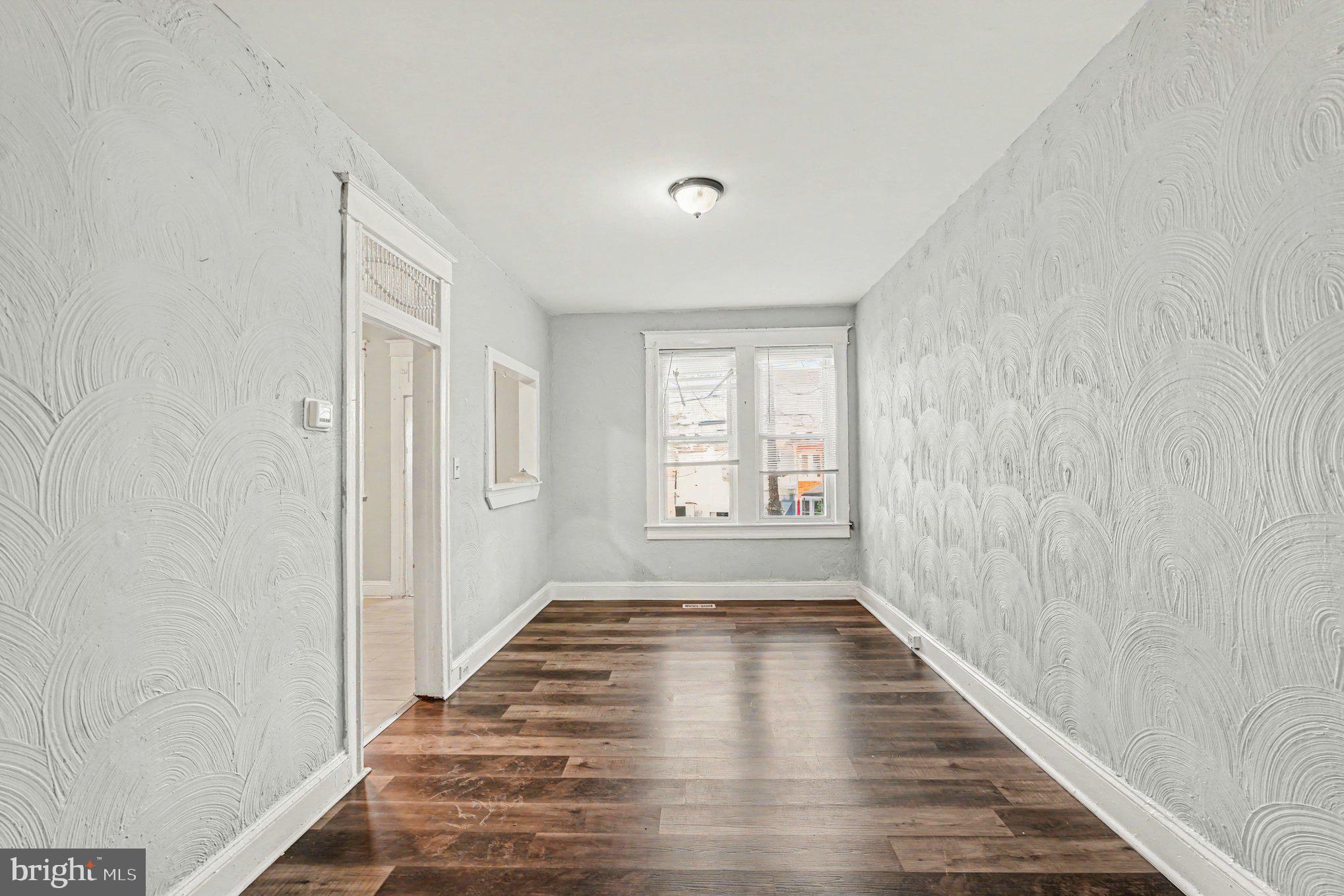 409 Edgewood Street Baltimore, MD 21229 - Photo 10 of 30 a view of a hallway with wooden floor and a window